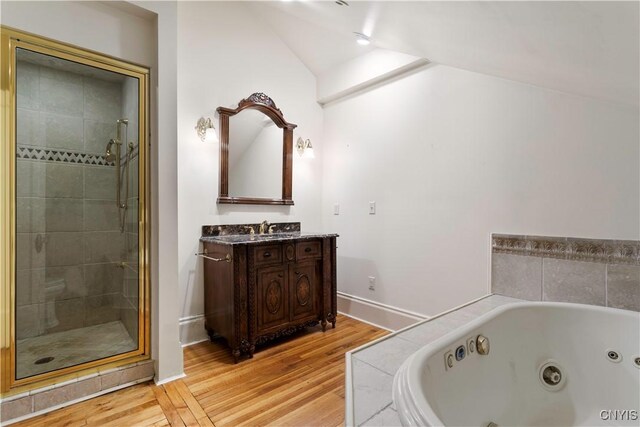 1208 James St, Syracuse, NY 13203 - bathroom with vanity, vaulted ceiling, independent shower and bath, and wood-type flooring