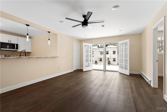 1208 James St, Syracuse, NY 13203 - unfurnished living room with ceiling fan, a baseboard heating unit, dark hardwood / wood-style flooring, and french doors
