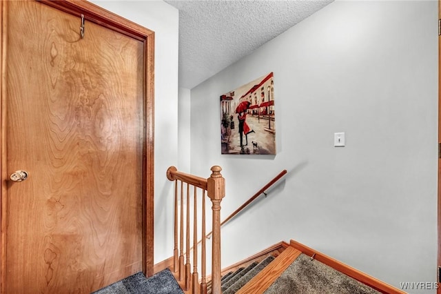 stairway featuring a textured ceiling