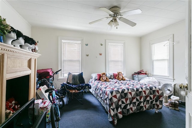 bedroom featuring multiple windows, ceiling fan, and carpet