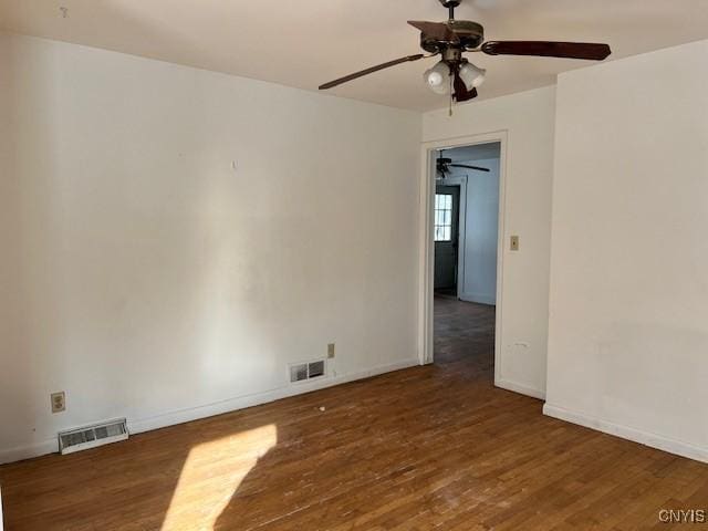 unfurnished room with a ceiling fan, baseboards, visible vents, and wood finished floors