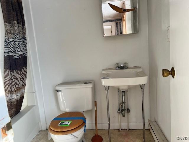 full bathroom with toilet and a shower with shower curtain