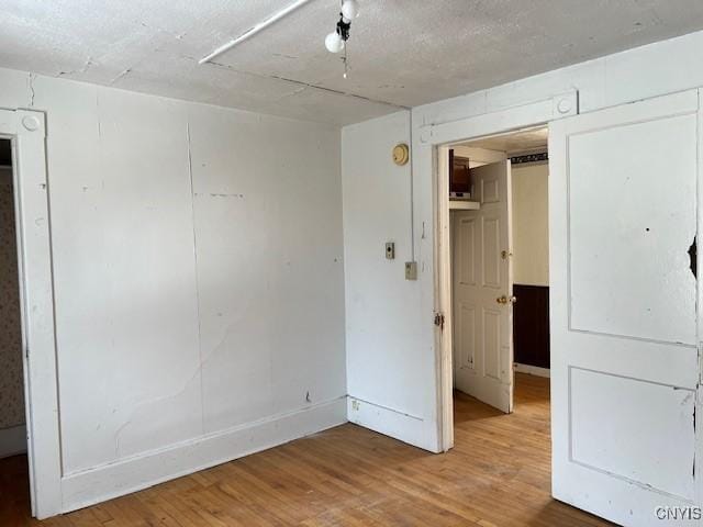 unfurnished bedroom with a closet, baseboards, and wood finished floors