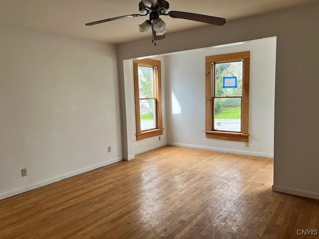spare room with baseboards, a ceiling fan, and wood finished floors