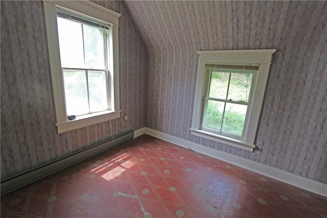 additional living space featuring vaulted ceiling and baseboard heating