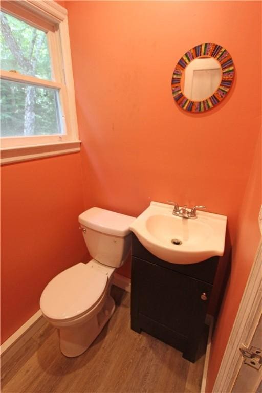 bathroom with vanity, wood-type flooring, and toilet