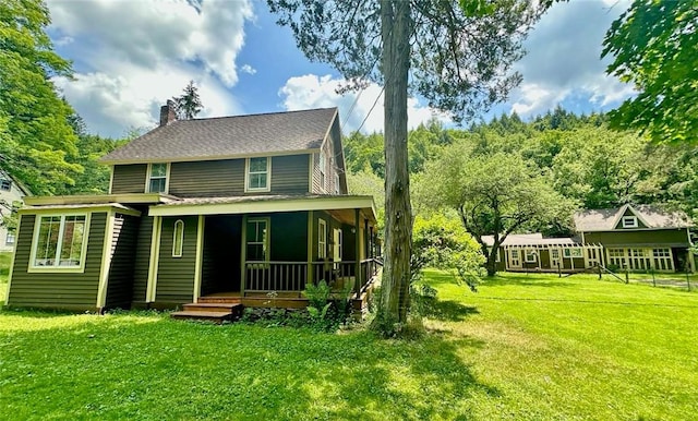 back of property with a lawn and a sunroom