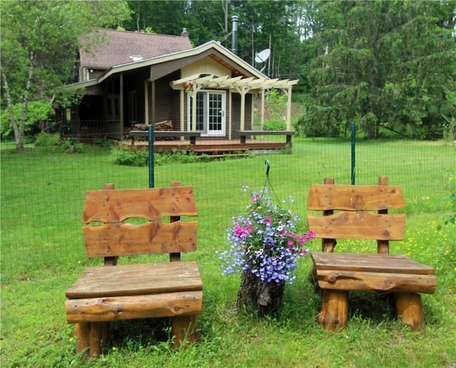 view of property's community featuring a wooden deck, a pergola, and a lawn