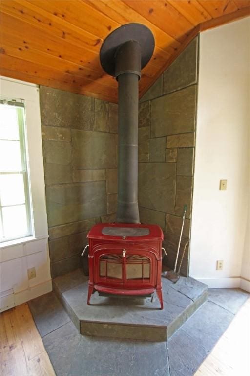 interior details featuring wood-type flooring, a wood stove, and wooden ceiling