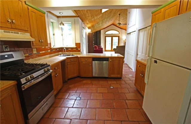 kitchen with vaulted ceiling, appliances with stainless steel finishes, sink, hanging light fixtures, and kitchen peninsula