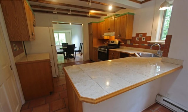 kitchen featuring a baseboard radiator, kitchen peninsula, sink, and stainless steel gas range oven