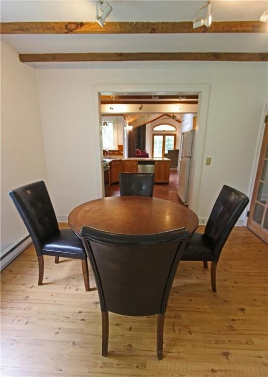 dining room with a baseboard heating unit, light hardwood / wood-style flooring, and beamed ceiling