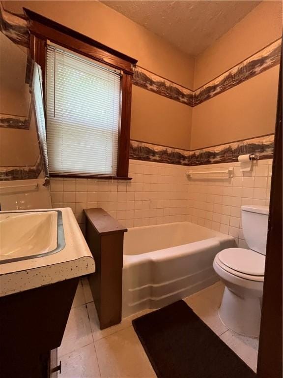 bathroom featuring tile walls, a bathtub, tile patterned flooring, toilet, and a textured ceiling