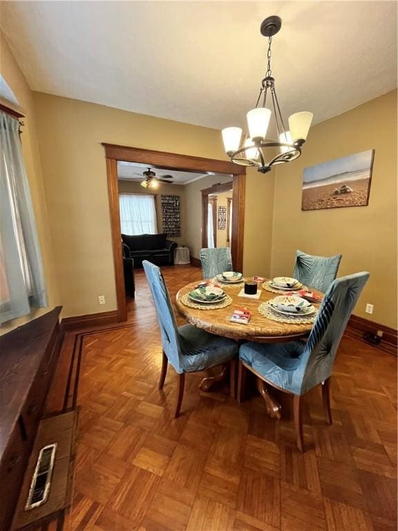 dining area featuring an inviting chandelier and dark parquet floors