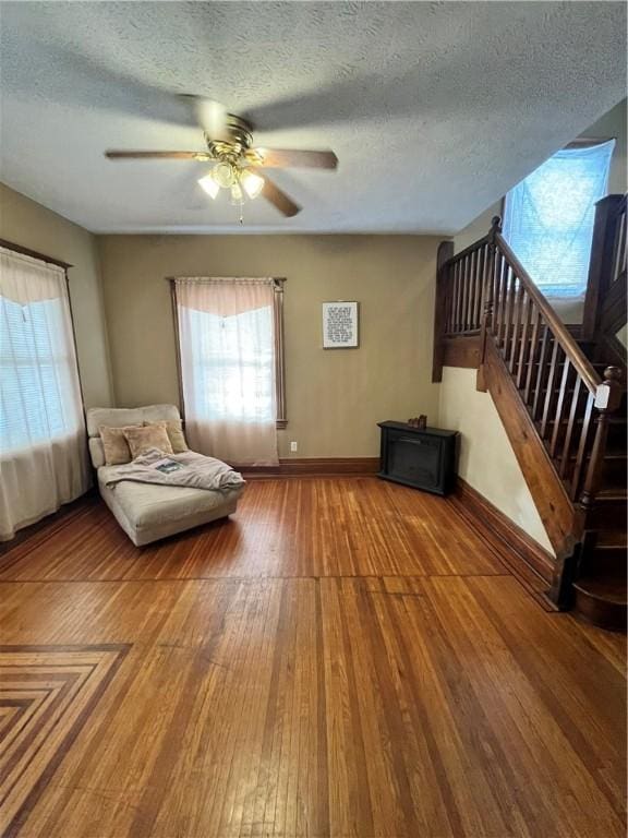 unfurnished room featuring ceiling fan, wood-type flooring, and a textured ceiling