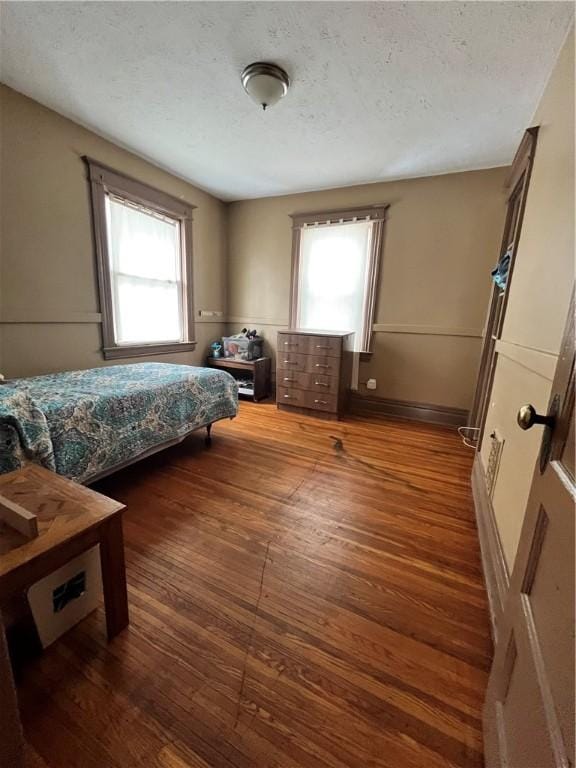 bedroom featuring dark hardwood / wood-style flooring and a textured ceiling