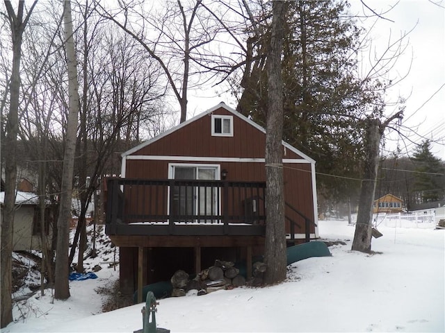 snow covered rear of property featuring a deck