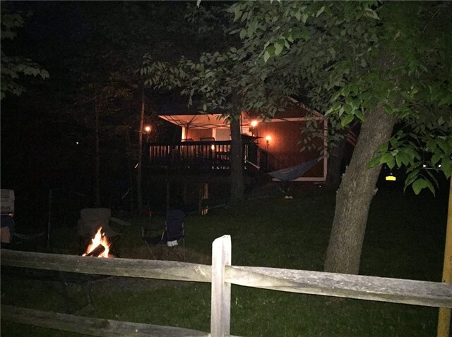 6024 W Willow Pt, Canadice, NY 14471 - back of house at twilight featuring an outdoor fire pit, a deck, and fence