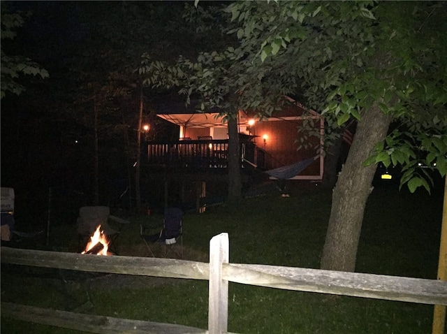 6024 W Willow Pt, Canadice, NY 14471 - back of house at twilight featuring an outdoor fire pit, a deck, and fence