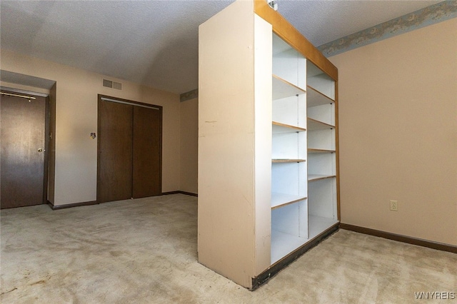 unfurnished bedroom with light carpet and a textured ceiling