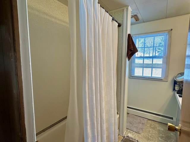 bathroom with a baseboard heating unit and shower / bath combo with shower curtain