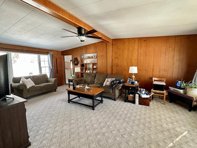 living room featuring wood walls, vaulted ceiling with beams, ceiling fan, light carpet, and a textured ceiling