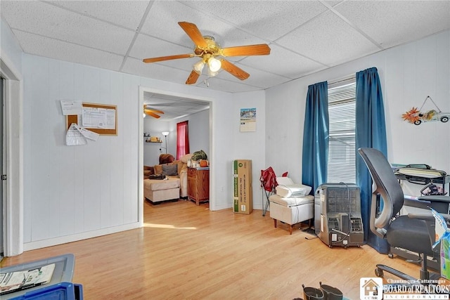 office space with ceiling fan, a paneled ceiling, and wood-type flooring