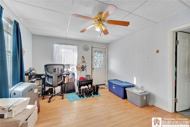 interior space with ceiling fan, a paneled ceiling, and hardwood / wood-style floors