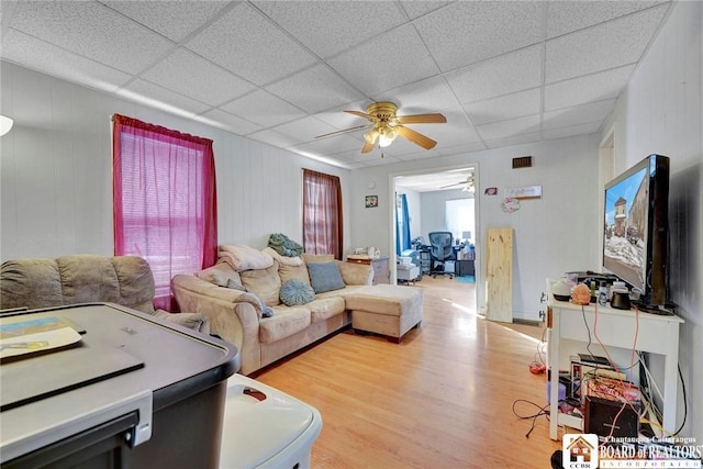 living room featuring light hardwood / wood-style flooring, ceiling fan, and a paneled ceiling