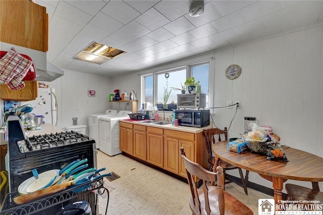 kitchen with white refrigerator, washing machine and dryer, and sink