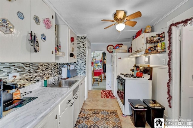 kitchen with ornamental molding, sink, white gas stove, and white cabinets