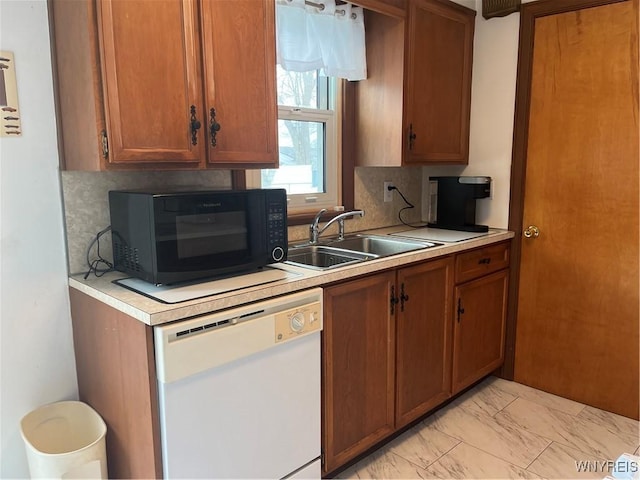 kitchen featuring white dishwasher, sink, and backsplash