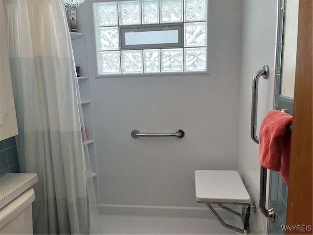 bathroom with curtained shower and toilet