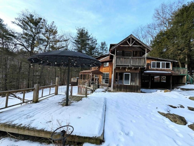 snow covered house featuring a gazebo and a deck