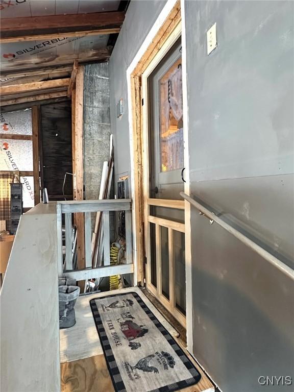 miscellaneous room with beamed ceiling and wood-type flooring