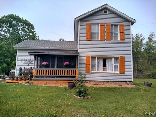 rear view of house featuring a lawn