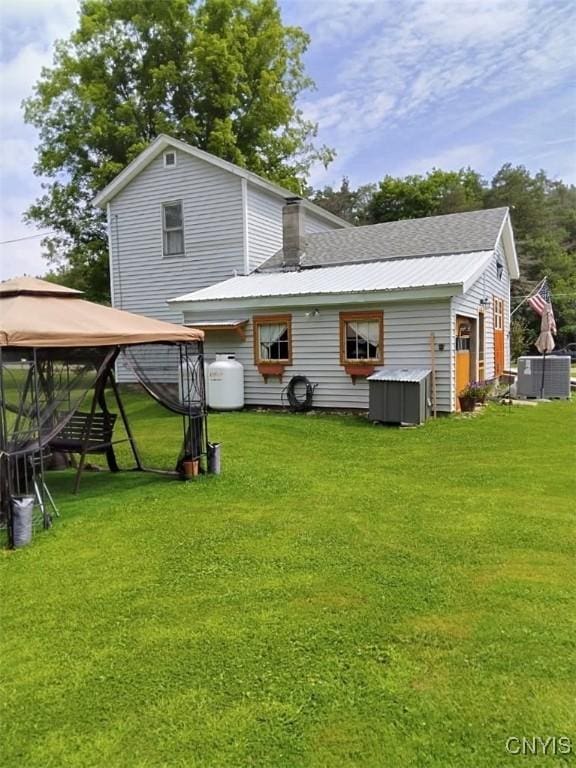 back of house featuring a yard, a gazebo, and central AC unit