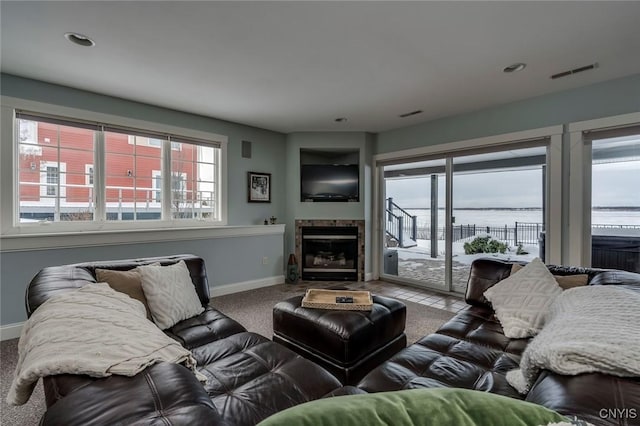 carpeted living room featuring a tiled fireplace