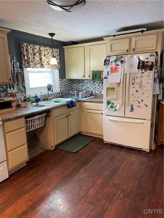 kitchen featuring sink, decorative light fixtures, dark wood-type flooring, and white fridge with ice dispenser