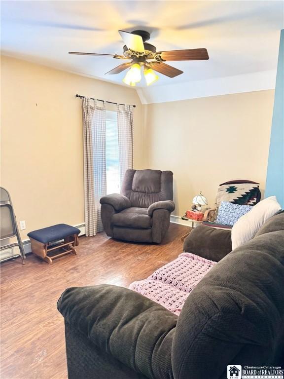 living room with hardwood / wood-style floors, vaulted ceiling, and ceiling fan