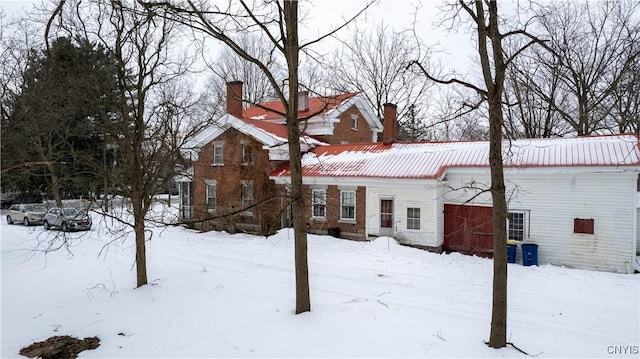 exterior space with metal roof and a chimney