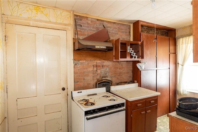 kitchen with brick wall, gas range gas stove, light countertops, open shelves, and brown cabinetry