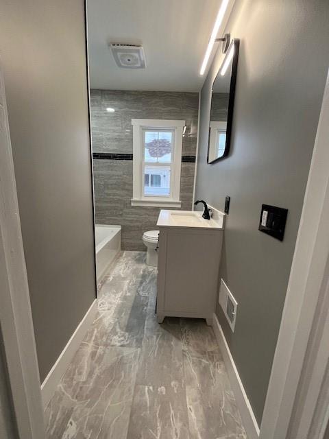 full bathroom featuring vanity, toilet, bathing tub / shower combination, and tile walls