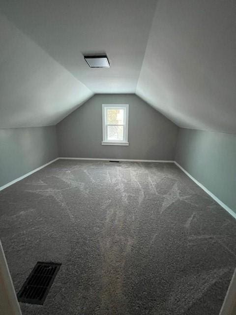 bonus room with lofted ceiling and carpet