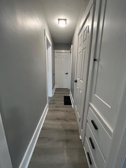 corridor with dark hardwood / wood-style flooring