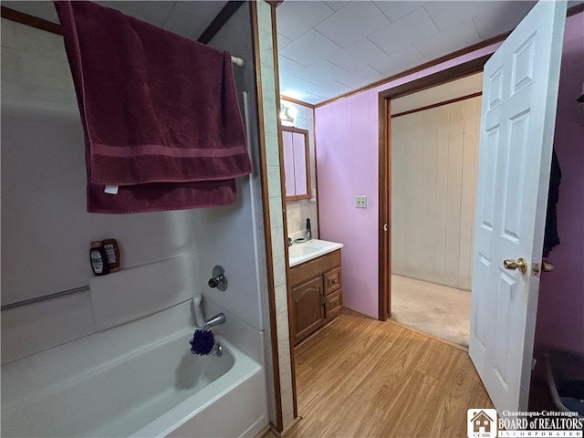 bathroom featuring vanity, hardwood / wood-style floors, and bathing tub / shower combination