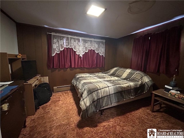 carpeted bedroom featuring a baseboard heating unit and wood walls