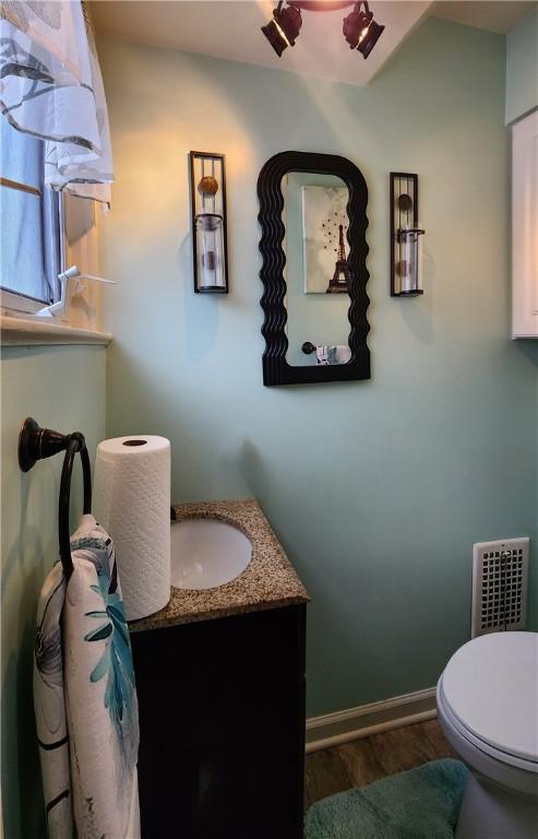 bathroom featuring vanity, hardwood / wood-style floors, and toilet