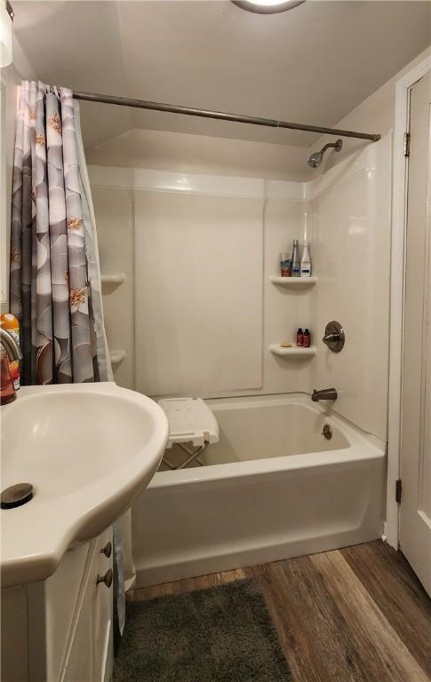 bathroom featuring hardwood / wood-style floors and shower / bath combo with shower curtain