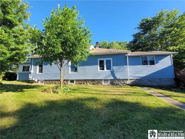 rear view of property featuring a lawn